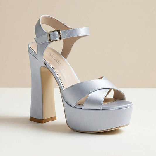A single platform silver satin sandal with a high block heel, featuring a light silver satin finish, an ankle strap with a buckle, and a beige insole, shown against a neutral beige background. lebanon