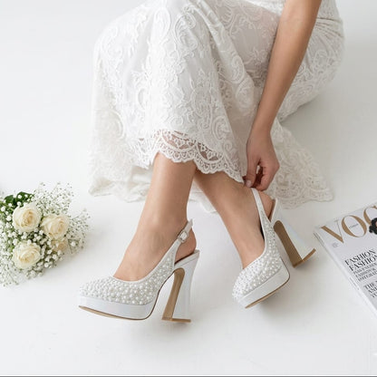 Bride in lace dress adjusting her pearl white double platform wedding shoes by White Lily Brides in Beirut, Lebanon.