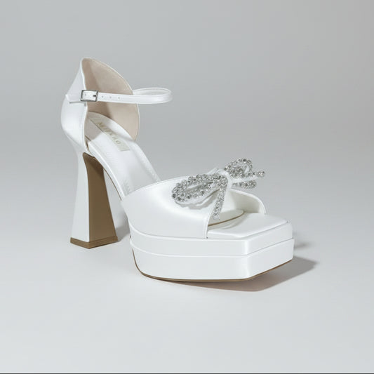 White Lily Brides pearlescent chunky platform wedding shoe featuring a crystal bow embellishment, square toe, and delicate ankle strap