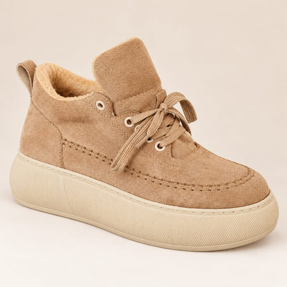Side view of a camel beige women's platform sneaker with cozy fleece lining, rounded toe and cream rubber sole on a light beige background.